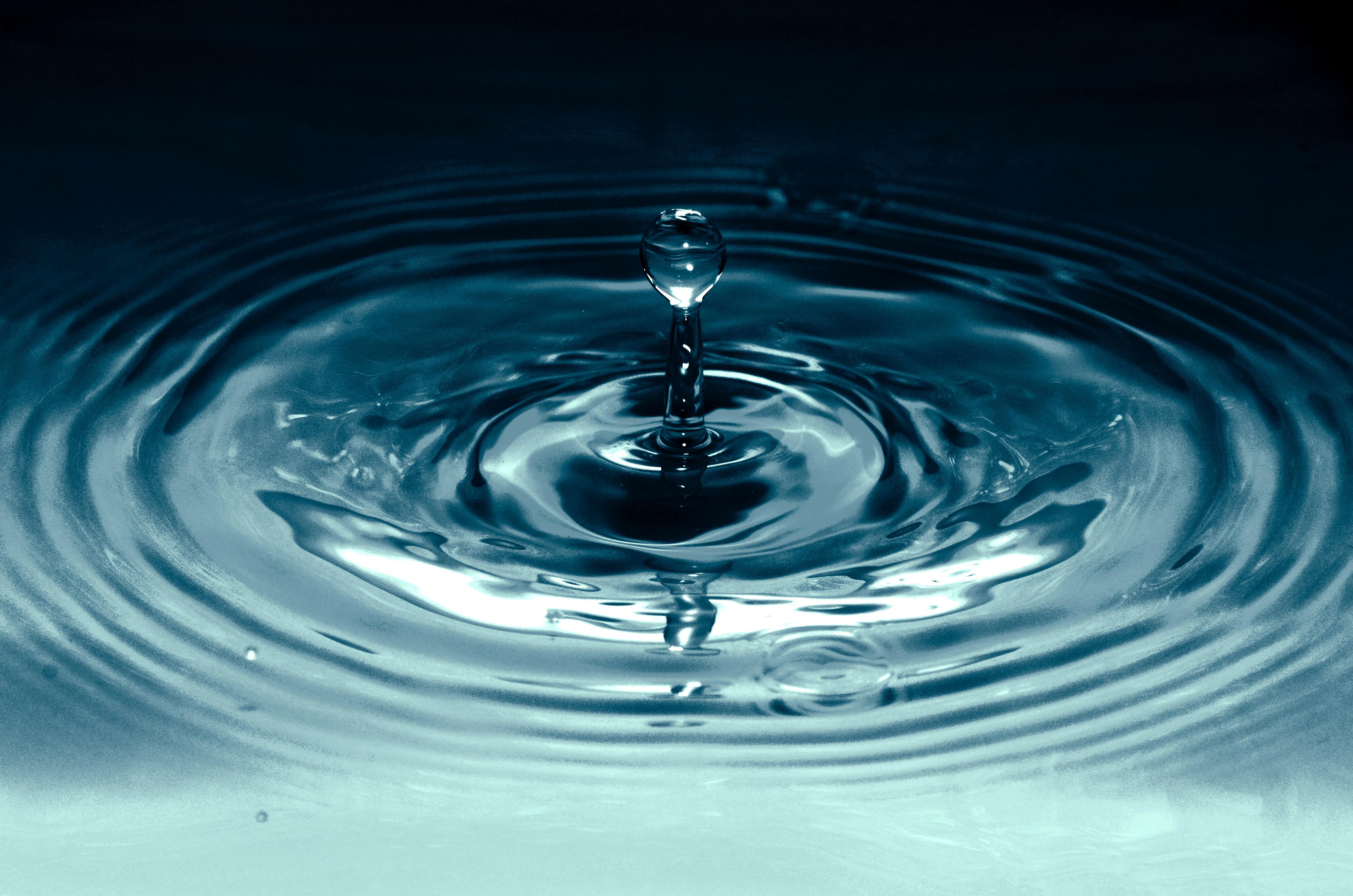 A water droplet falling into a ripple with a light beam illuminating a pool of thoughts, representing private therapy in Milborne St Andrew, serving Blandford, Dorchester, and Central Dorset.